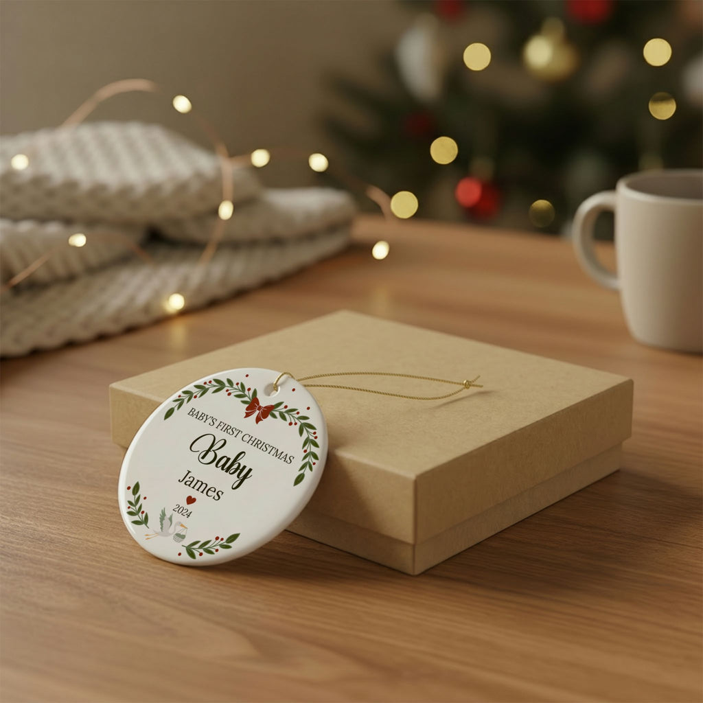 A round ceramic Christmas ornament featuring a custom dog portrait and the text 'THAT PERSON IS MY FUR-EVER HOME', resting on a kraft gift box on a wooden table with a blurred festive background.