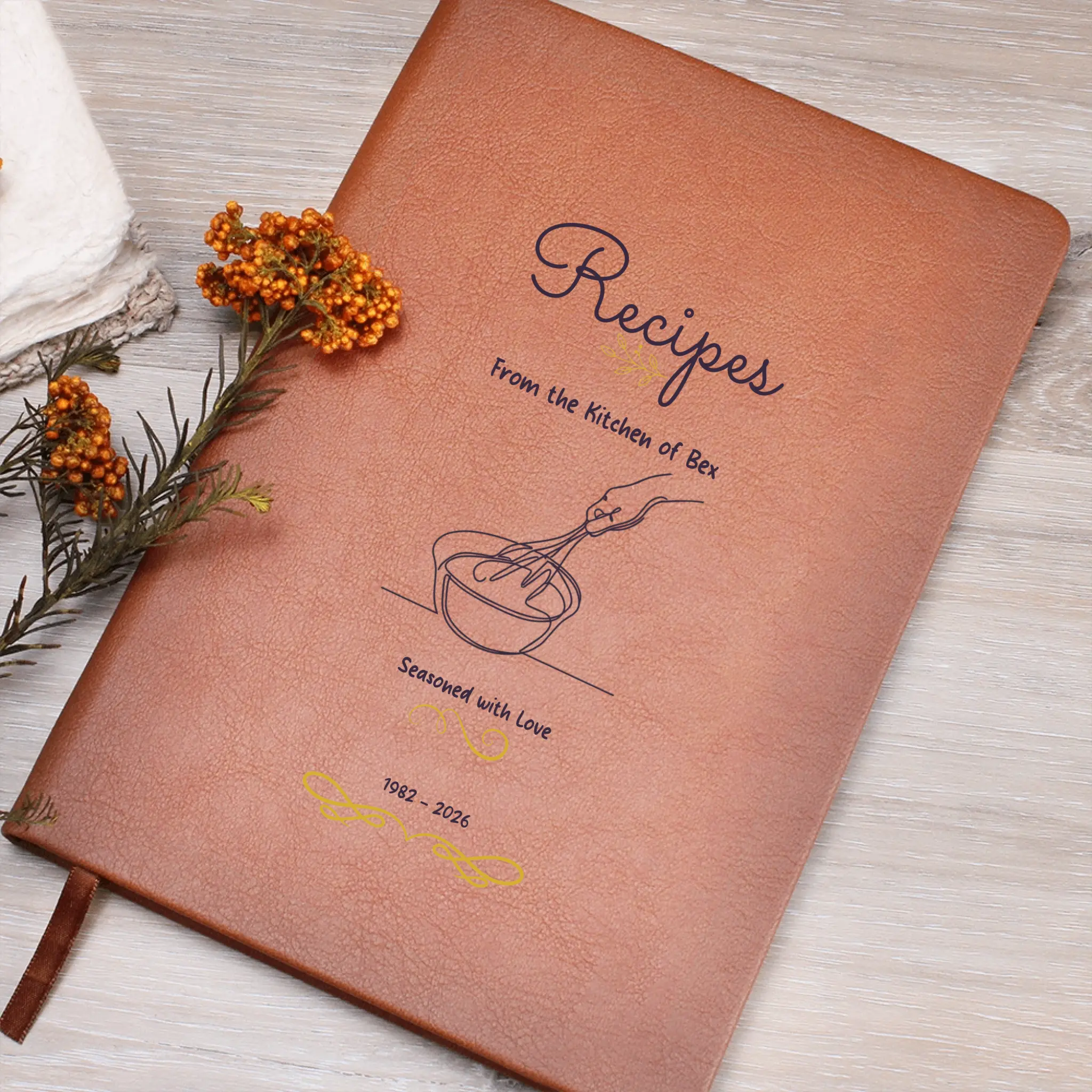Brown recipe book with 'Recipes' title and illustrations on a wooden surface