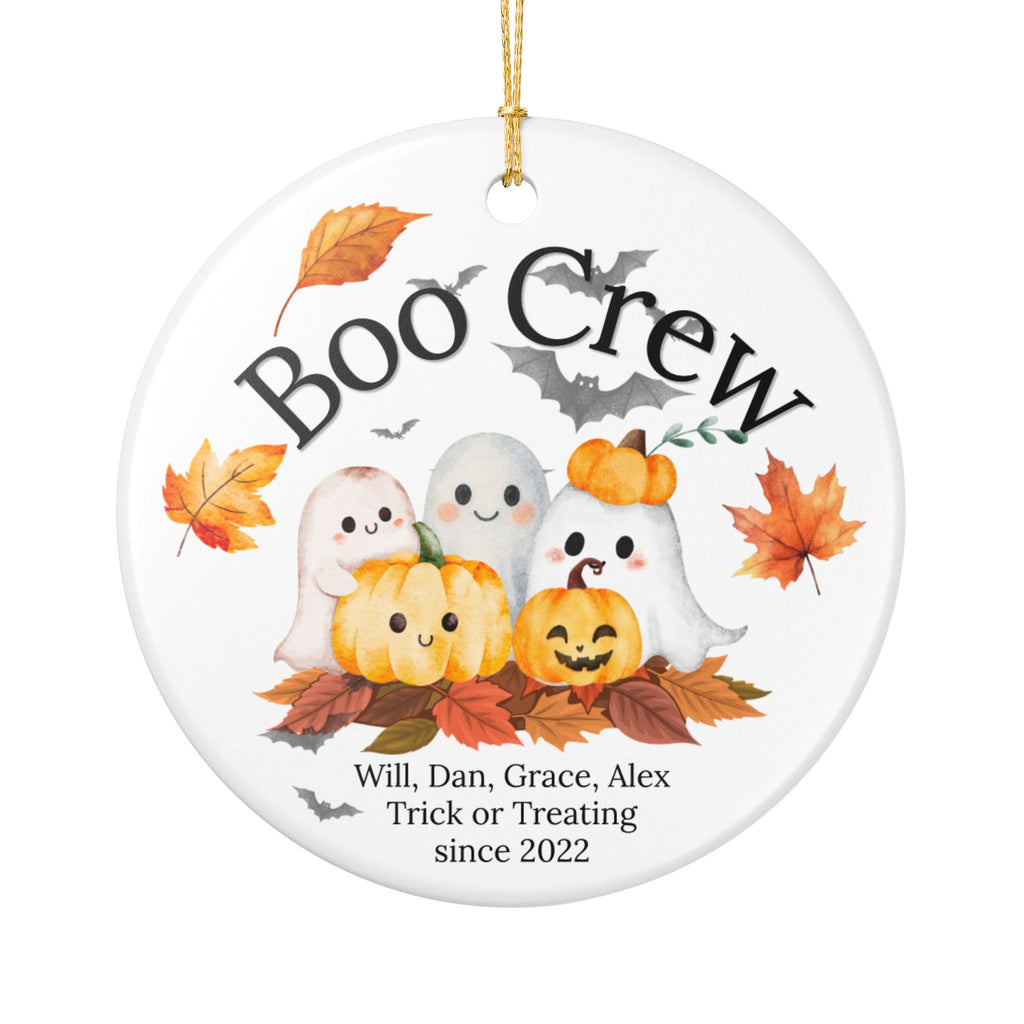 A round white ceramic Halloween ornament with a hanging loop, featuring a printed design of cute ghosts, pumpkins, autumn leaves, bats, and the text 'Boo Crew' plus a personalized list of names and the phrase 'Trick or Treating since 2022'.