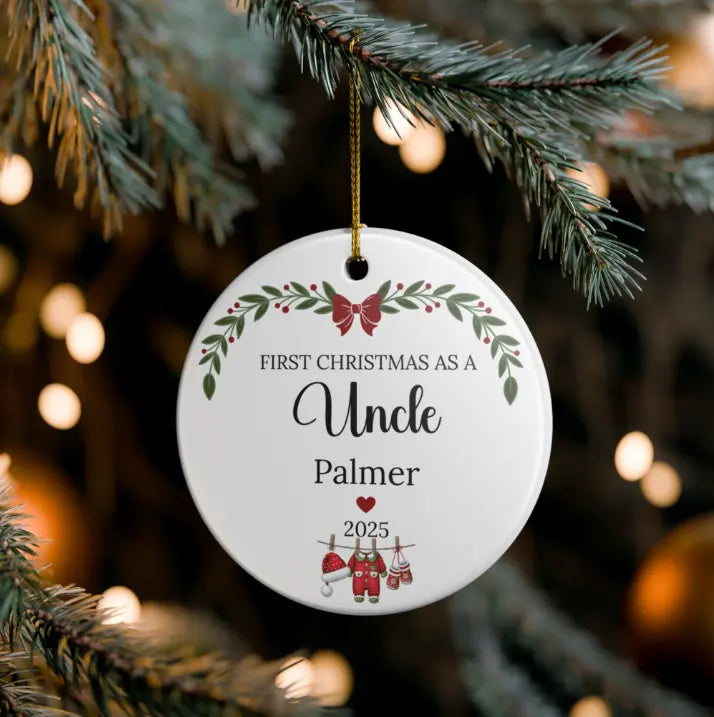 A round white ceramic Christmas ornament hanging from a pine branch. The ornament is personalized with the text 'FIRST CHRISTMAS AS A Uncle Palmer' and the year '2025', decorated with red and green holiday illustrations including a Santa Claus and stockings.