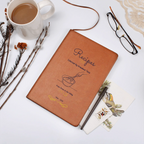 Brown notebook labeled 'Recipes' on a white surface with a cup of coffee, glasses, and decorative items.