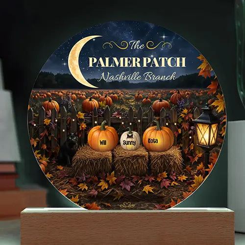 A round decorative plaque or light display on a wooden base, featuring a Halloween-themed illustration with pumpkins, autumn leaves, a crescent moon, and the text 'The PALMER PATCH Nashville Branch.' Personalized names appear on three pumpkins in the center scene.