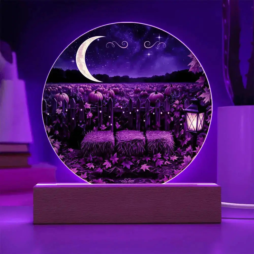 Round acrylic plaque featuring a purple pumpkin patch, crescent moon, and hay bales on a wooden LED light base.