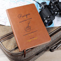 Brown notebook with text on a suitcase with binoculars and map in the background