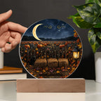 Round acrylic plaque featuring a moonlit pumpkin patch, hay bales, and a black cat on a wooden display stand.