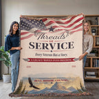 Woven veteran blanket with American flag, mountain landscape, and patriotic text held by two women.