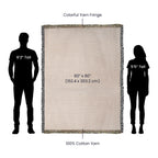 60x80 inch beige woven cotton blanket with colorful yarn fringe, shown for scale next to human silhouettes.